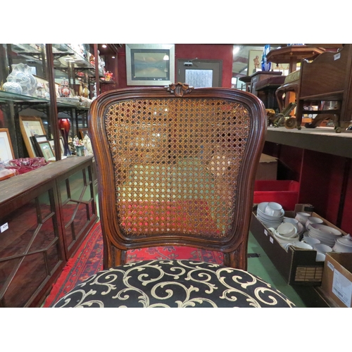 4207 - A French walnut 19th Century style cane back chair with carved decoration over a serpentine front se... 