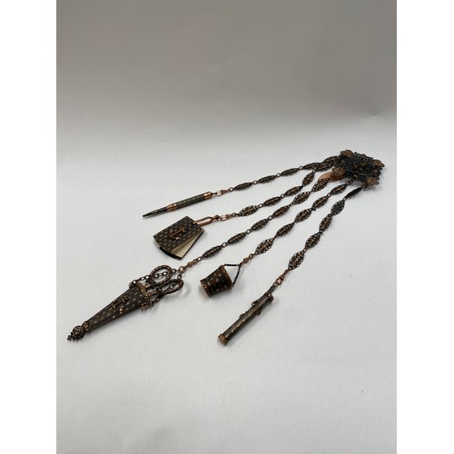 6719 - A gilt and pierced metal chatelaine, five attachments to include scissors, aide memoir, pencil, need... 