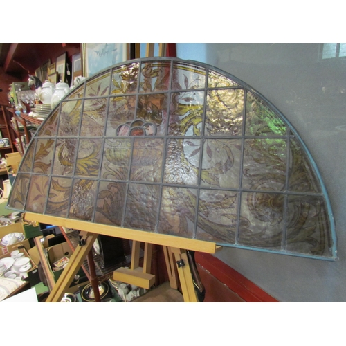 4015 - A stained and leaded glass arched panel, scrolled foliate handpainted design, 54cm x 108cm