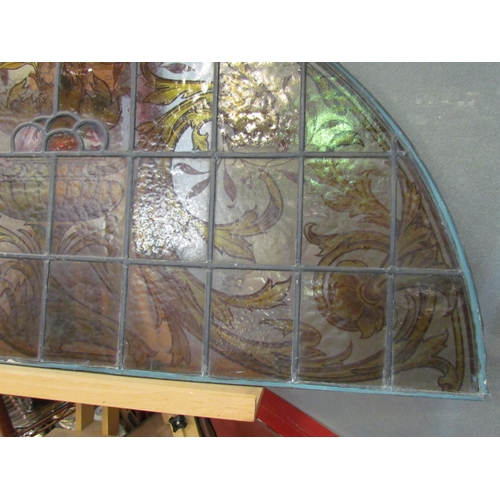 4015 - A stained and leaded glass arched panel, scrolled foliate handpainted design, 54cm x 108cm