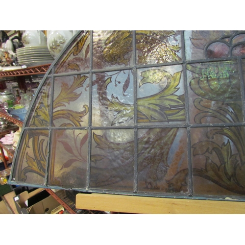 4015 - A stained and leaded glass arched panel, scrolled foliate handpainted design, 54cm x 108cm