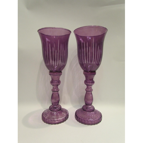 4026 - A pair of amethyst glass candlesticks as large goblets, 33cm tall