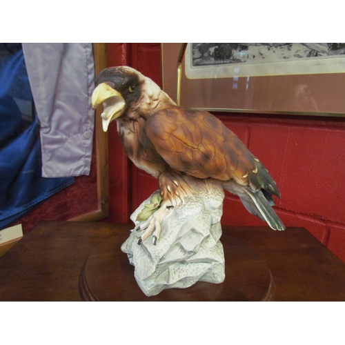 4162 - A ceramic figural table lamp as bird of prey on rocky outcrop, green shade