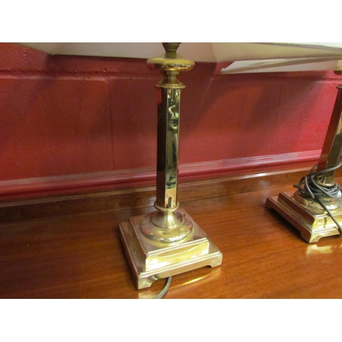 4166 - A pair of brass faceted column form table lamps with shades