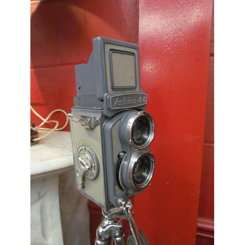 4169 - A cased Yashica-44 twin lens reflex camera on tripod stand and with lens caps