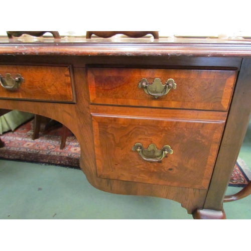 4206 - A George III style burr walnut crossbanded desk of four drawers with a shaped apron over cabriole le... 