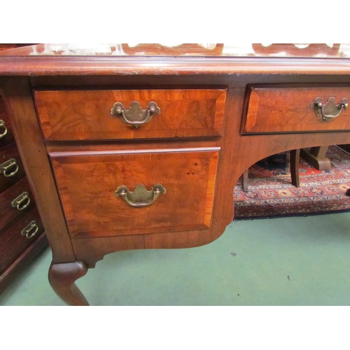 4206 - A George III style burr walnut crossbanded desk of four drawers with a shaped apron over cabriole le... 