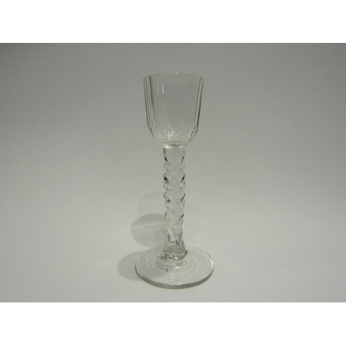 4391 - An 18th Century cordial glass with facet stem and bowl. 13.5cm high