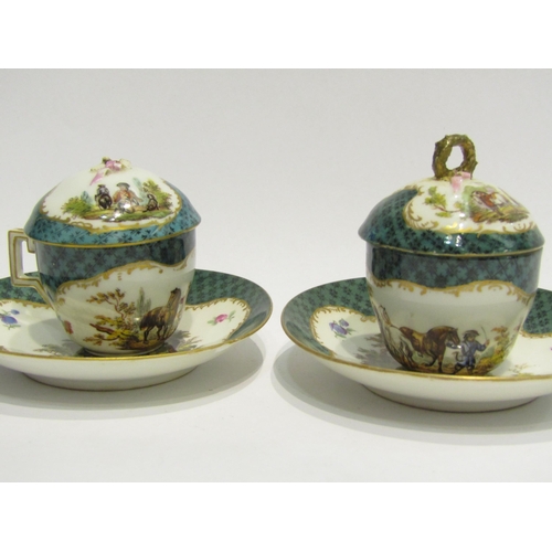 4413 - A pair of Meissen chocolate cups, hand-painted cartouche depicting figures on horse, gilt embellishm... 