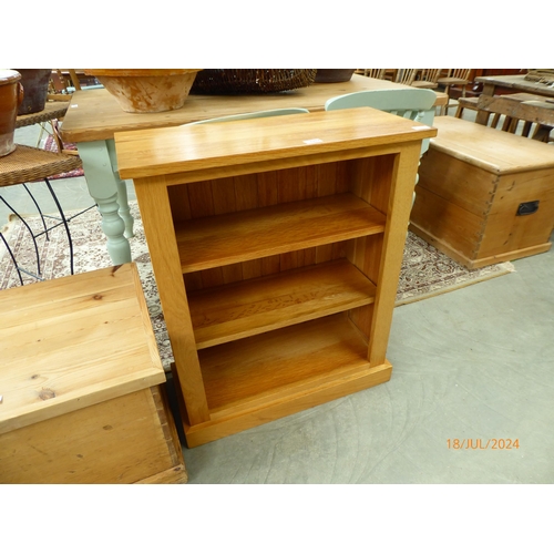 2310 - A light oak three tier shelving unit, plinth base