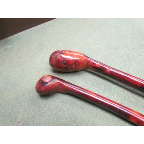 4255 - Two knobkerrie walking canes, one with carved face knop