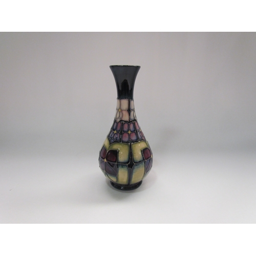 4290 - A Moorcroft 'Violet' pattern bud vase, tube lined with stylised purple violets on a dark blue ground... 