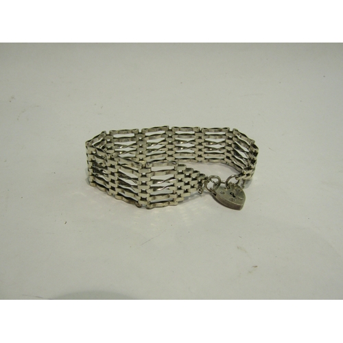 4440 - A silver six bar gate bracelet with silver heart shaped locket, marked Birmingham