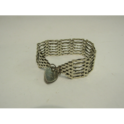 4440 - A silver six bar gate bracelet with silver heart shaped locket, marked Birmingham