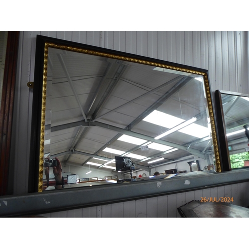 2135 - A black and gold framed mirror 102 x 69cm