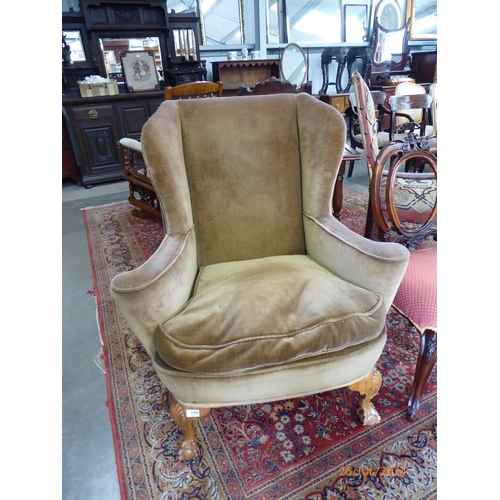 2206 - A 1930's Georgian style walnut wing chair on ball and claw legs