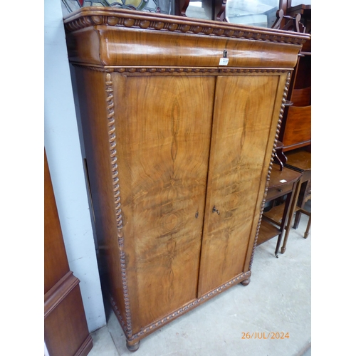 2220 - An early 19th Century continental walnut wardrobe of unusual design, with a cushion-moulded drawer a... 