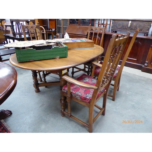 2251 - An Ercol elm extending leaf dining table with four chairs