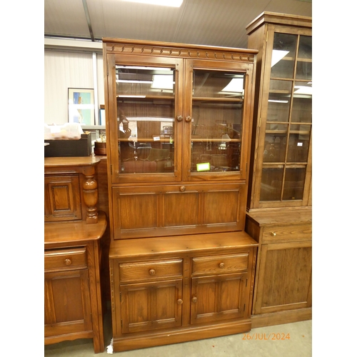 2326 - An Ercol elm full height cabinet, the glazed top over a two drawer and two door cupboard base