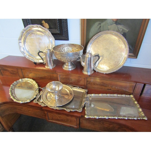 1017 - A selection of silver plate and metalware. A basin, a pair of café-au-lait, six trays and a repousse... 