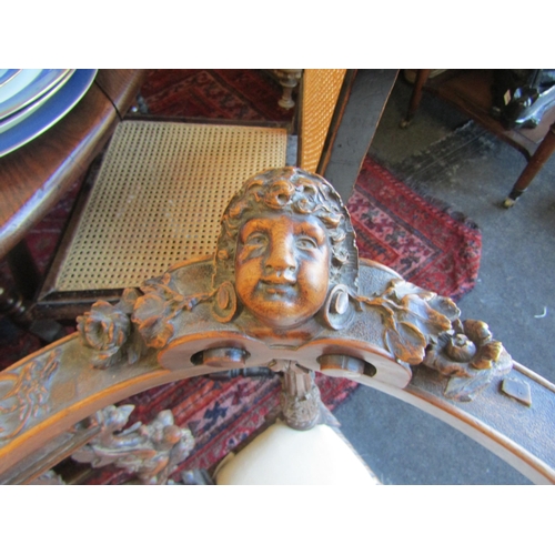 1027 - A 19th Century walnut ornate three seater settee, carved cherubs and mask detail, for re-covering, l... 