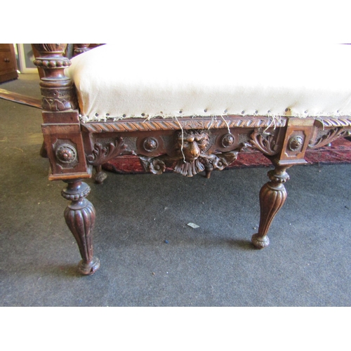 1027 - A 19th Century walnut ornate three seater settee, carved cherubs and mask detail, for re-covering, l... 