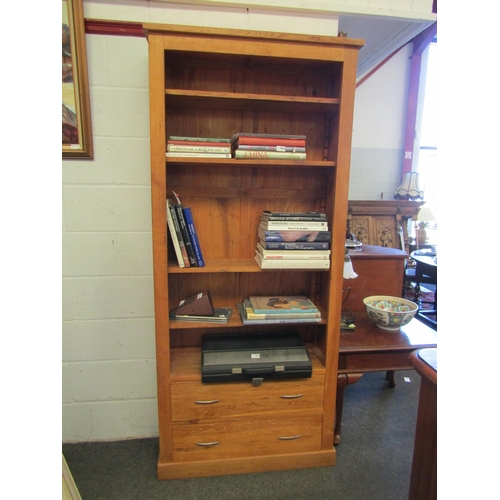 1038 - An “Oak Furnitureland” full height oak bookshelf with height adjustable shelves over two base drawer... 