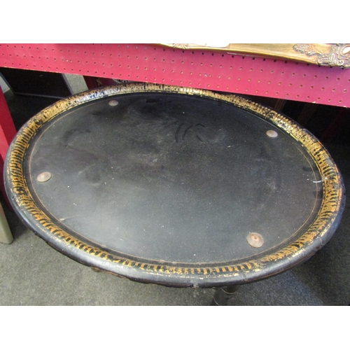 1055 - A lacquered oval papier mache tray on stand, 48cm tall x 70cm long