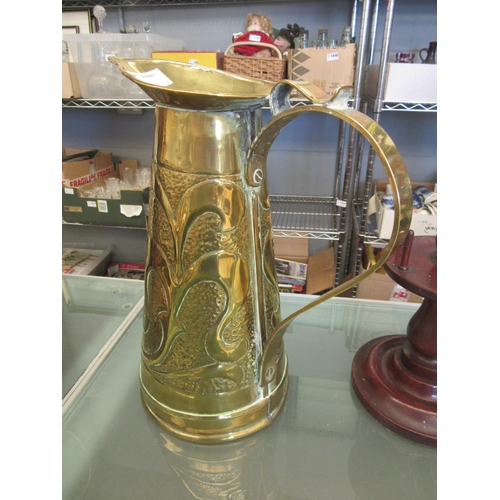 1506 - A gilt metal ewer with scroll handle and all-over classical relief, 31cm tall