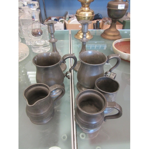 1511 - A pair of pewter candlesticks and five tankards (7)