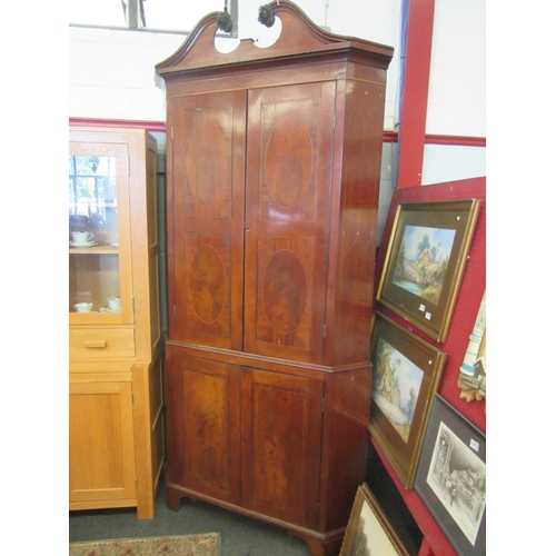 1076 - A George III mahogany double height corner cabinet, broken arch top pediment adorned with roses on b... 