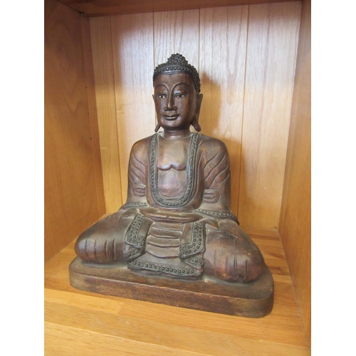 1078 - A carved wood Buddha figure sitting cross legged, 33cm tall