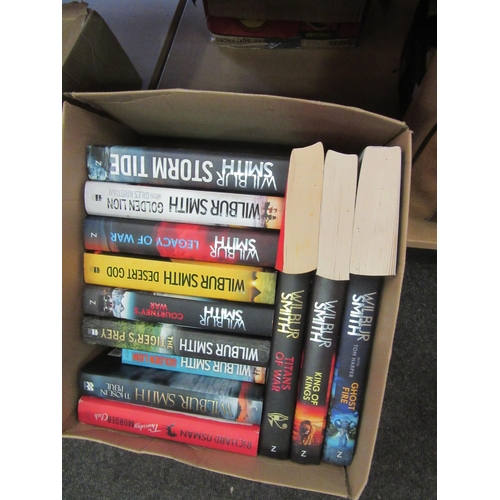 1183 - Two boxes of novels including authors Terry Pratchett, Bernard Cornwell and Wilber Smith