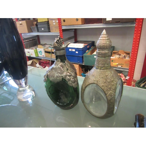 1208A - Two dimpled glass decanters, one decorated with grape and vine, the other Eastern hammered