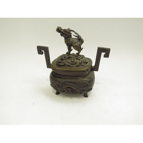 6706 - A bronze censor, the lid surmounted by a dragon dog, 13.5cm x 13cm