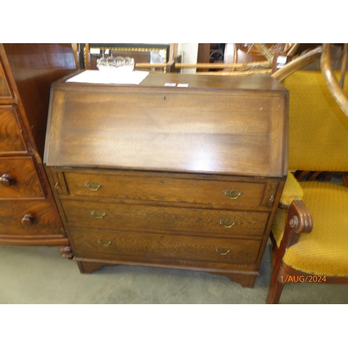 2125 - A 20th Century oak bureau, the fall front over three long drawers and bracket feet