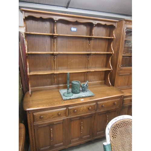 2344 - An Ercol elm dresser, the plate rack back over three drawer and three door cupboard base