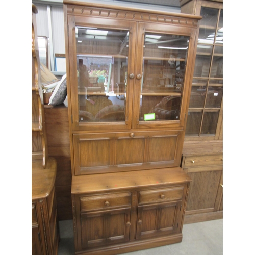 2346 - An Ercol elm full height cabinet, the glazed top over a two drawer and two door cupboard base