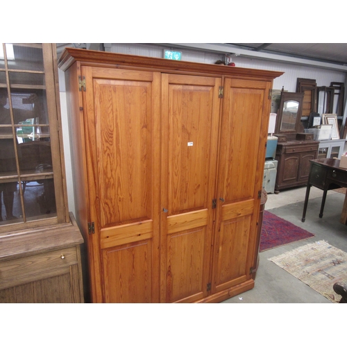 2348 - A modern pine and three door wardrobe with shelves and hangers to interiors