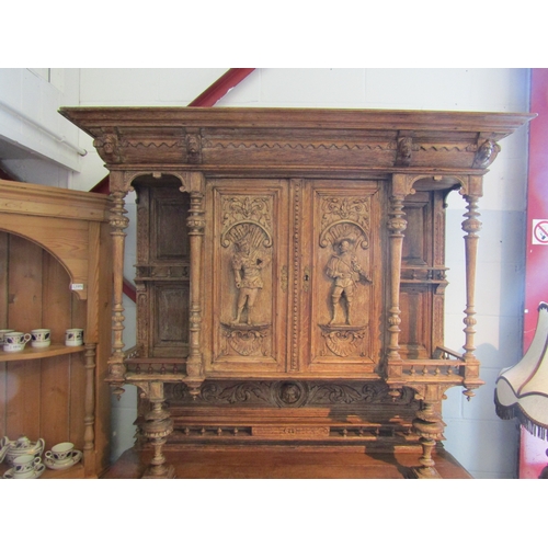 1007 - A carved oak 'Breton' style buffet with figural detail, masks and foliage, some losses, handle missi... 