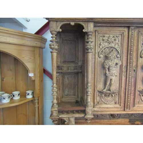 1007 - A carved oak 'Breton' style buffet with figural detail, masks and foliage, some losses, handle missi... 