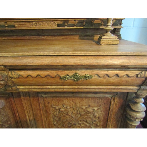 1007 - A carved oak 'Breton' style buffet with figural detail, masks and foliage, some losses, handle missi... 