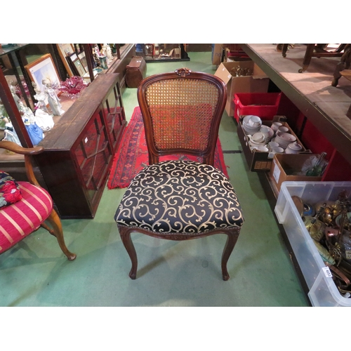 4004 - A French walnut 19th Century style cane back chair with carved decoration over a serpentine front se... 