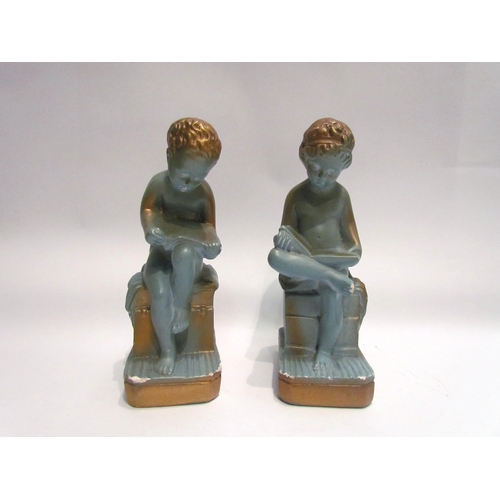 4029 - A pair of blue plaster cherubs, seated reading, with gilt embellishment, 24cm tall