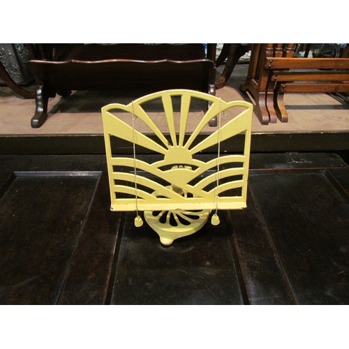4227 - A cast iron pale yellow cookbook stand with sunburst design