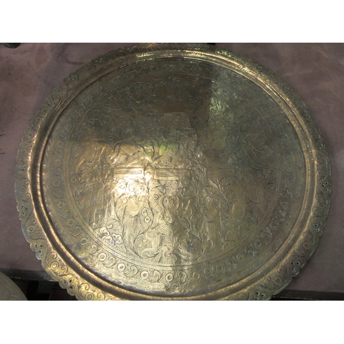 4013 - A large Asian brass charger with figural detail, 61cm diameter, with another smaller example, 35cm d... 