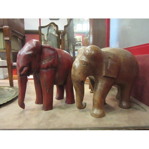 4018 - Two large carved wooden elephant figures, one red, tallest 31cm