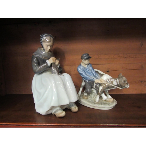 4031 - Two Royal Copenhagen figures, a seated woman sewing and a boy with cow. Woman dated 1911