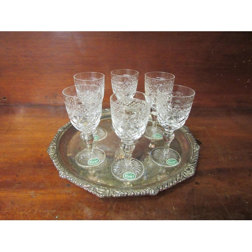 4079 - A silver plated tray, 27cm diameter, with six Stuart crystal sherry glasses