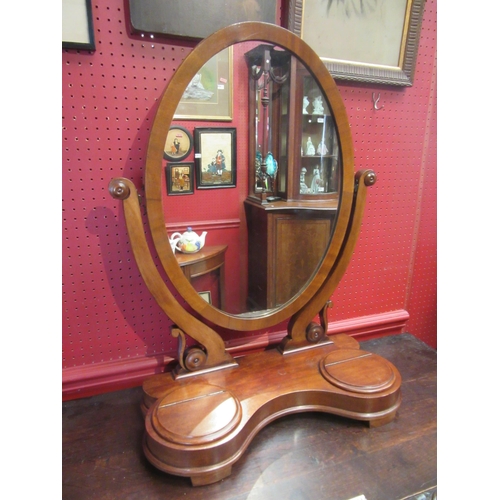 4111 - A mid-Victorian mahogany oval dressing chest tilting mirror on scroll supports and serpentine front ... 